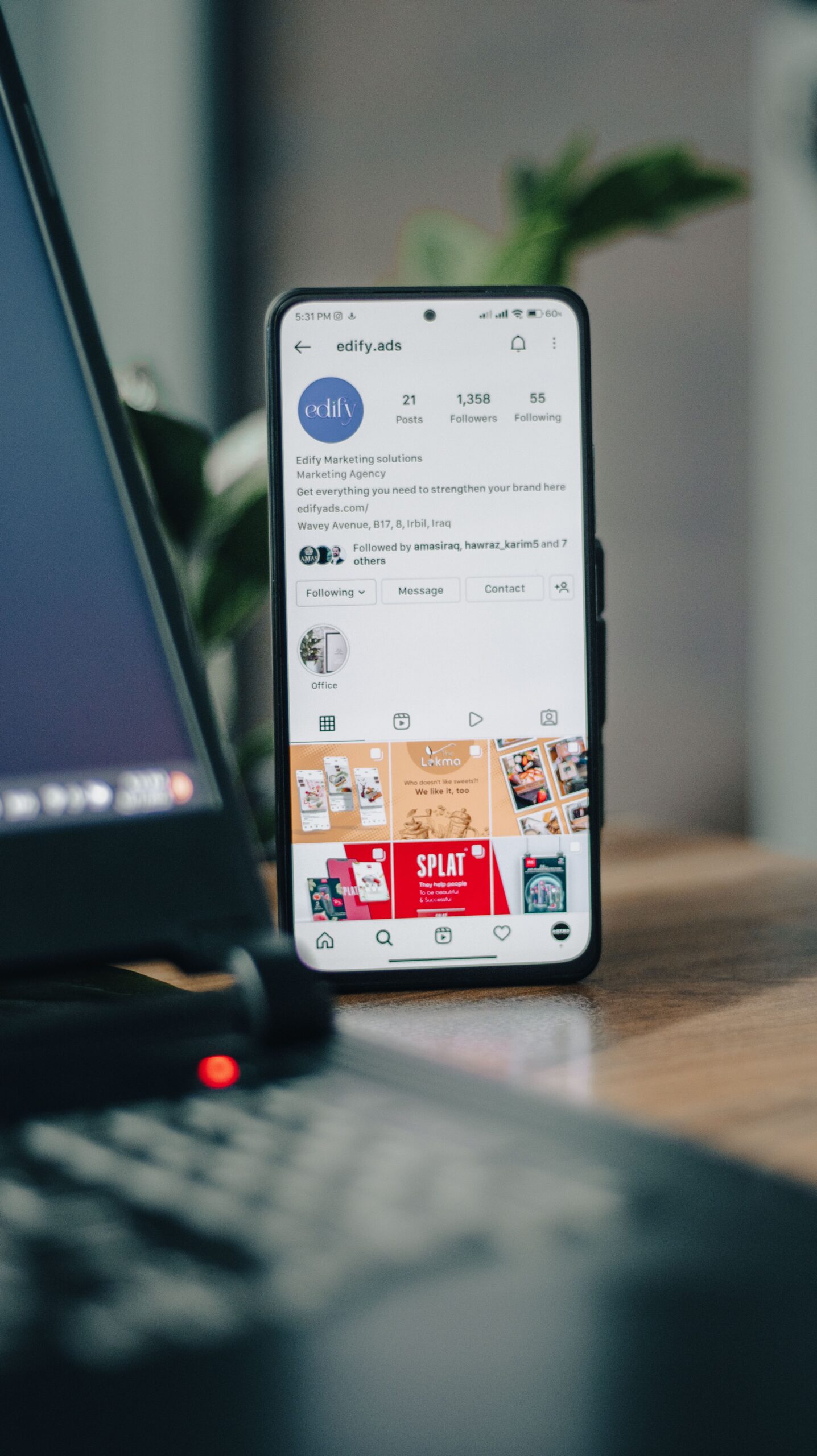 Smartphone displaying an Instagram profile next to a laptop, representing growth tool analytics